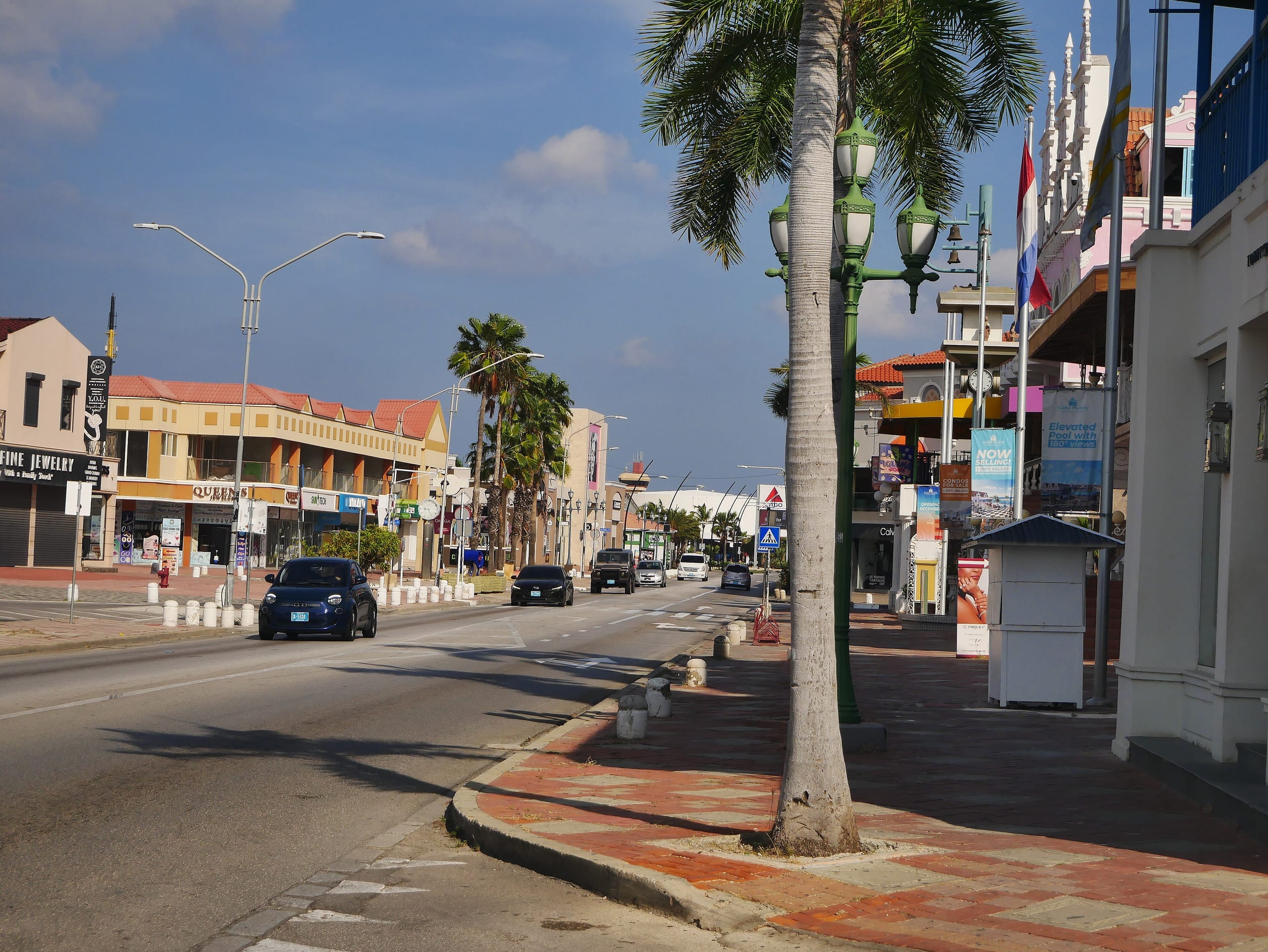 L.G. Smith Boulevard running through central Oranjestad, Aruba, lined with palms, shops and a pink gabled building
