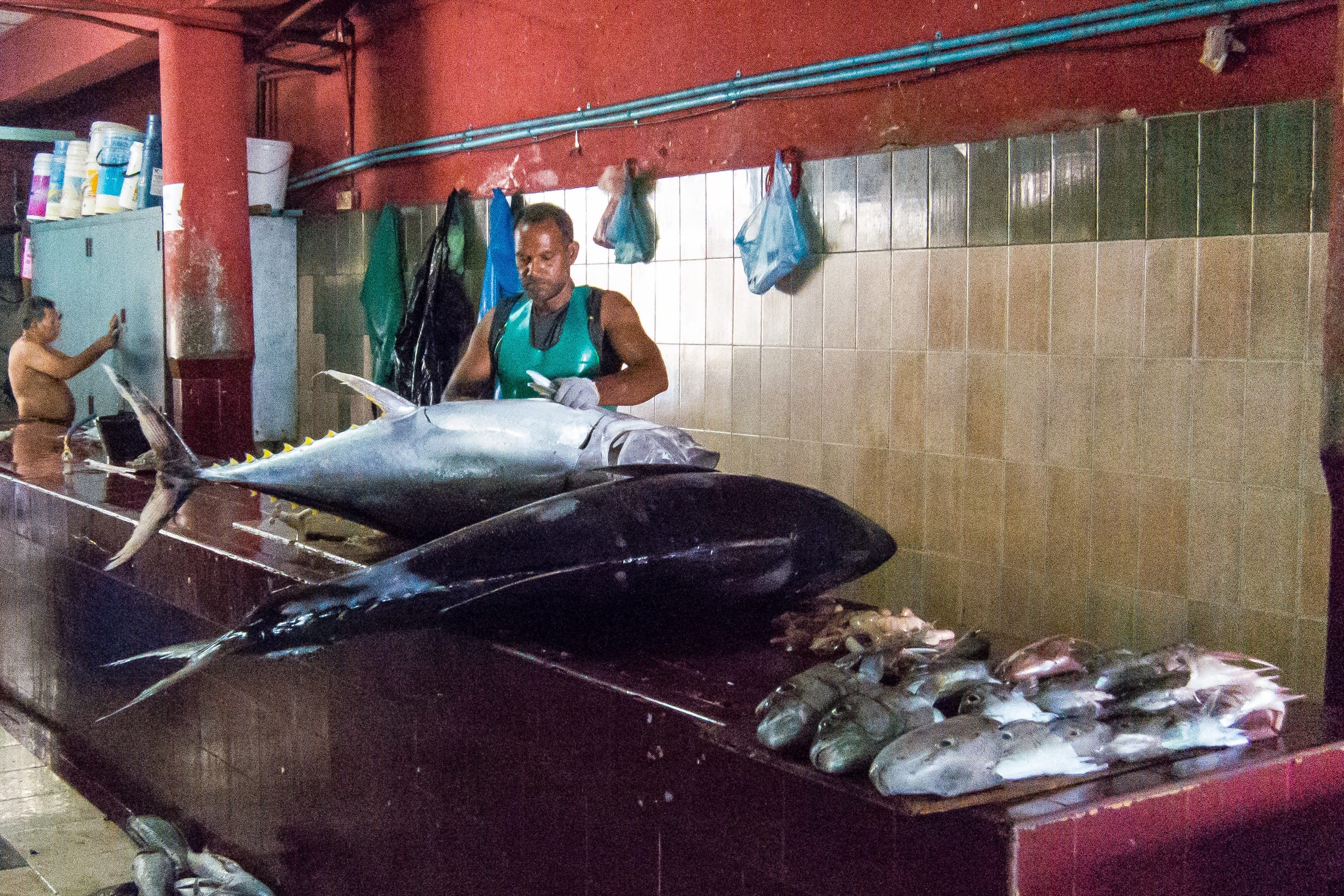 A fishmonger cutting up yellowfin tuna at the fish market in Malé, Maldives