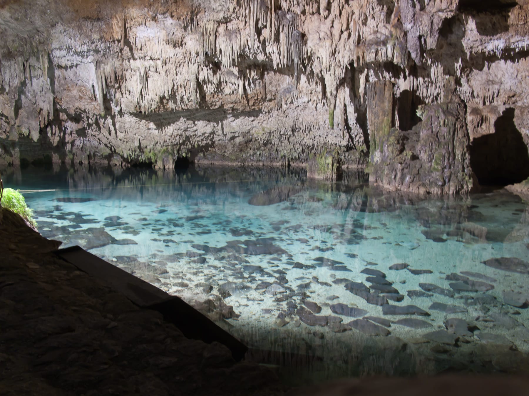 The cave pool of Cenote Choo-Ha near Coba, stalactites hanging over clear blue water
