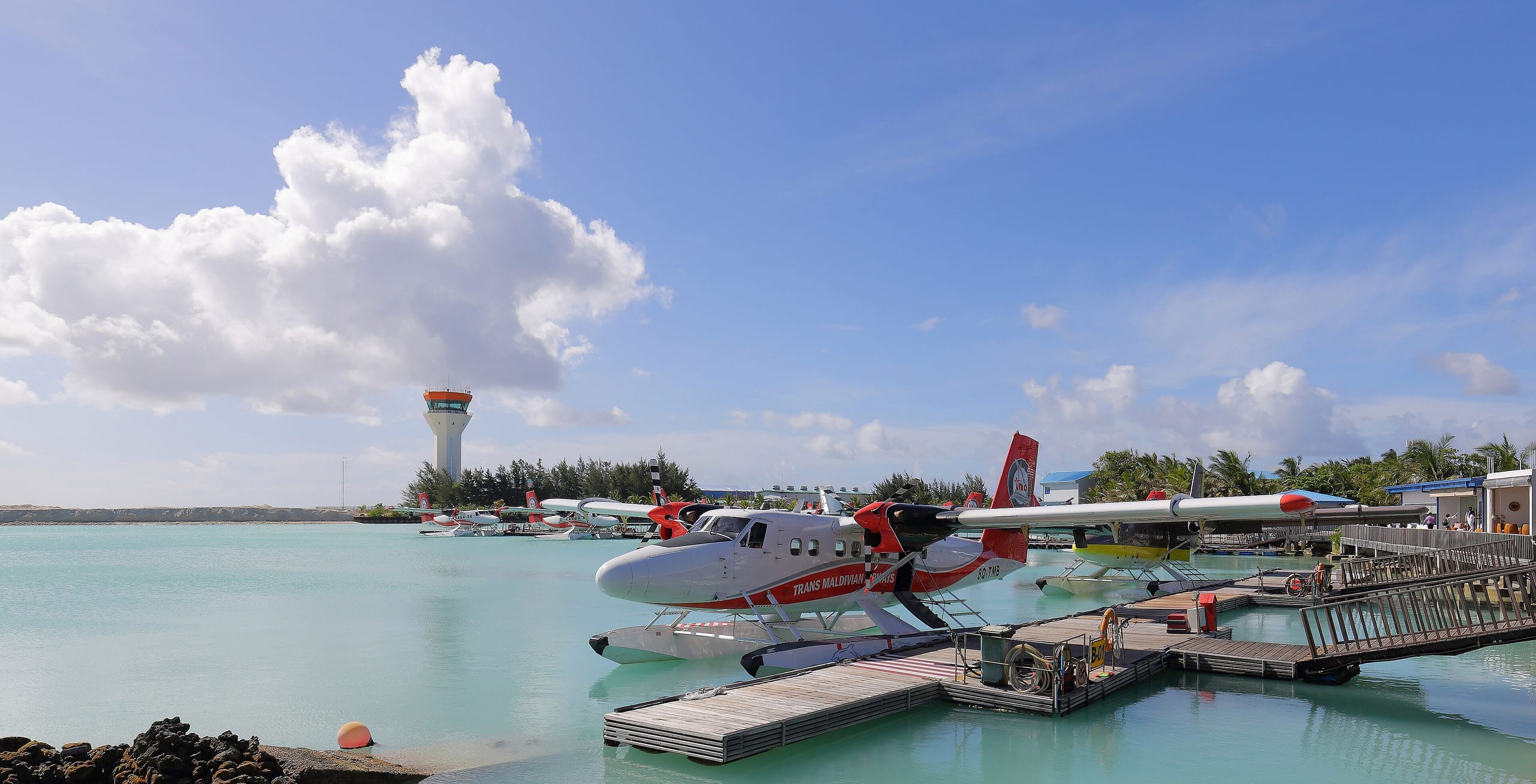 A Trans Maldivian Airways Twin Otter seaplane moored at the floating dock beside Velana International Airport