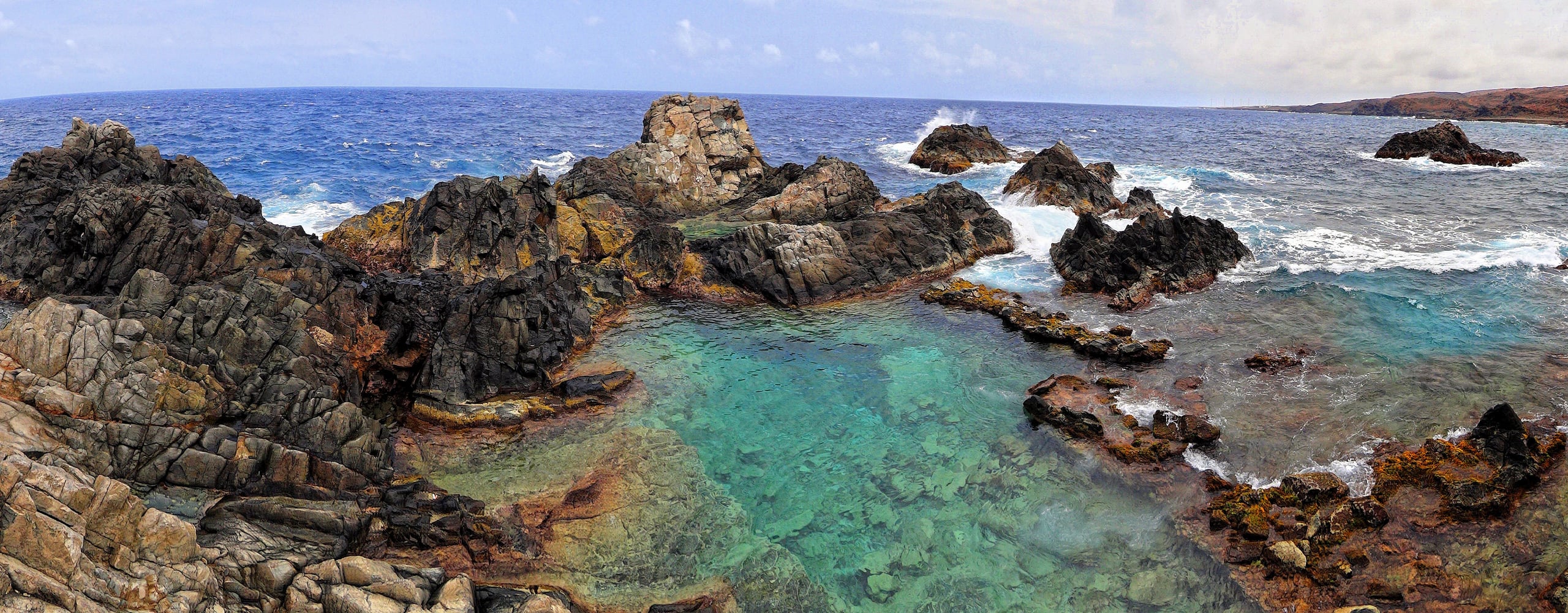 The Natural Pool at Conchi, a ring of dark rock holding turquoise water