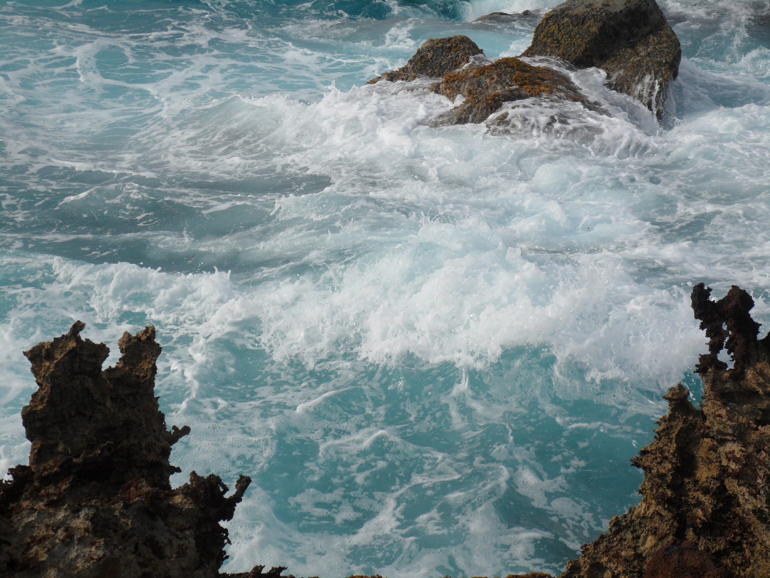 Waves breaking white over jagged rock at Andicuri on the east coast
