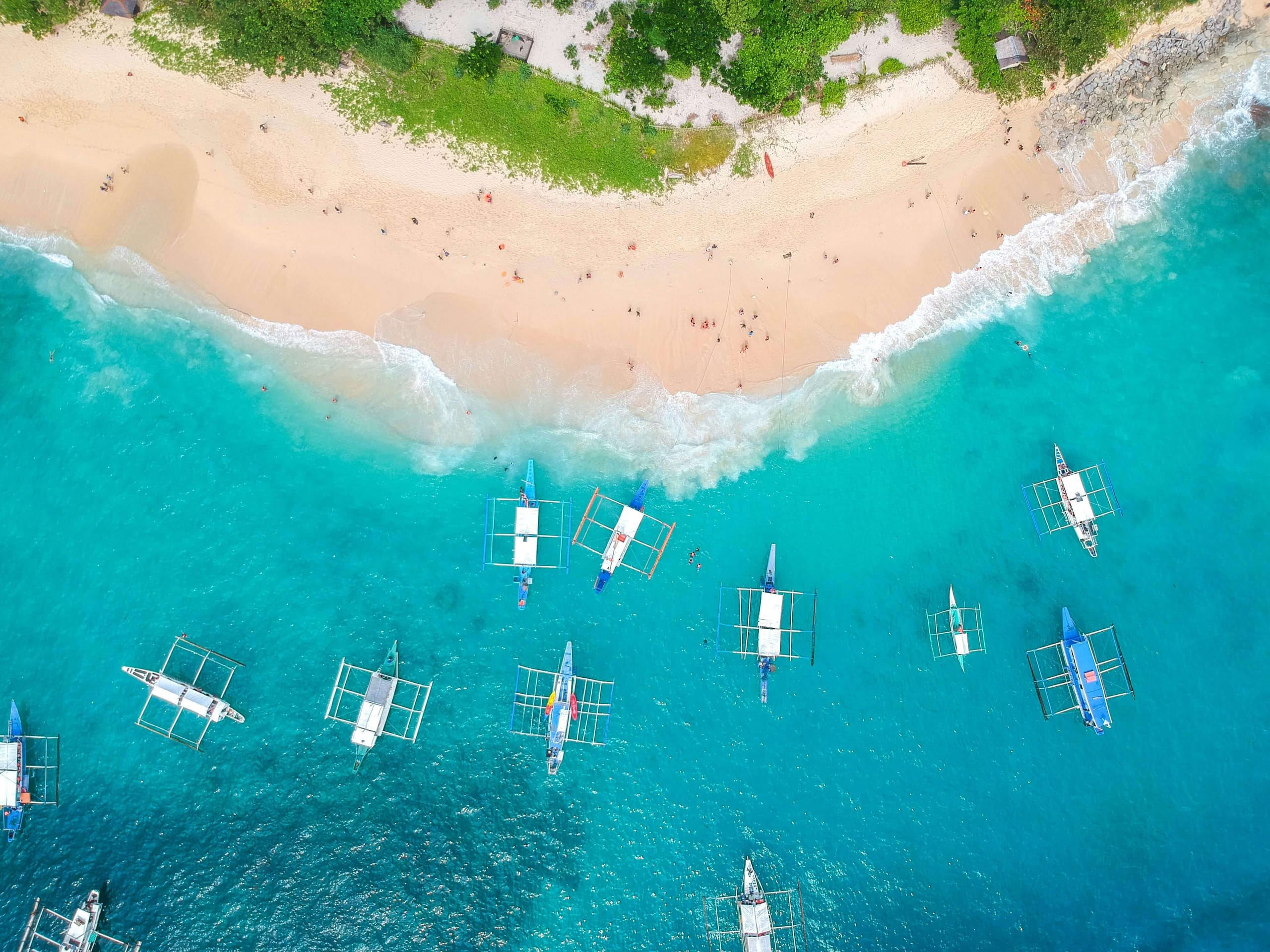 Straight down on Helicopter Island, a row of outrigger boats drawn up along the beach