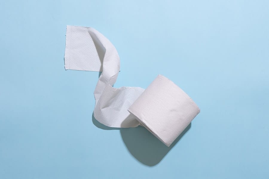 A roll of toilet paper, partly unrolled, on a pale blue background